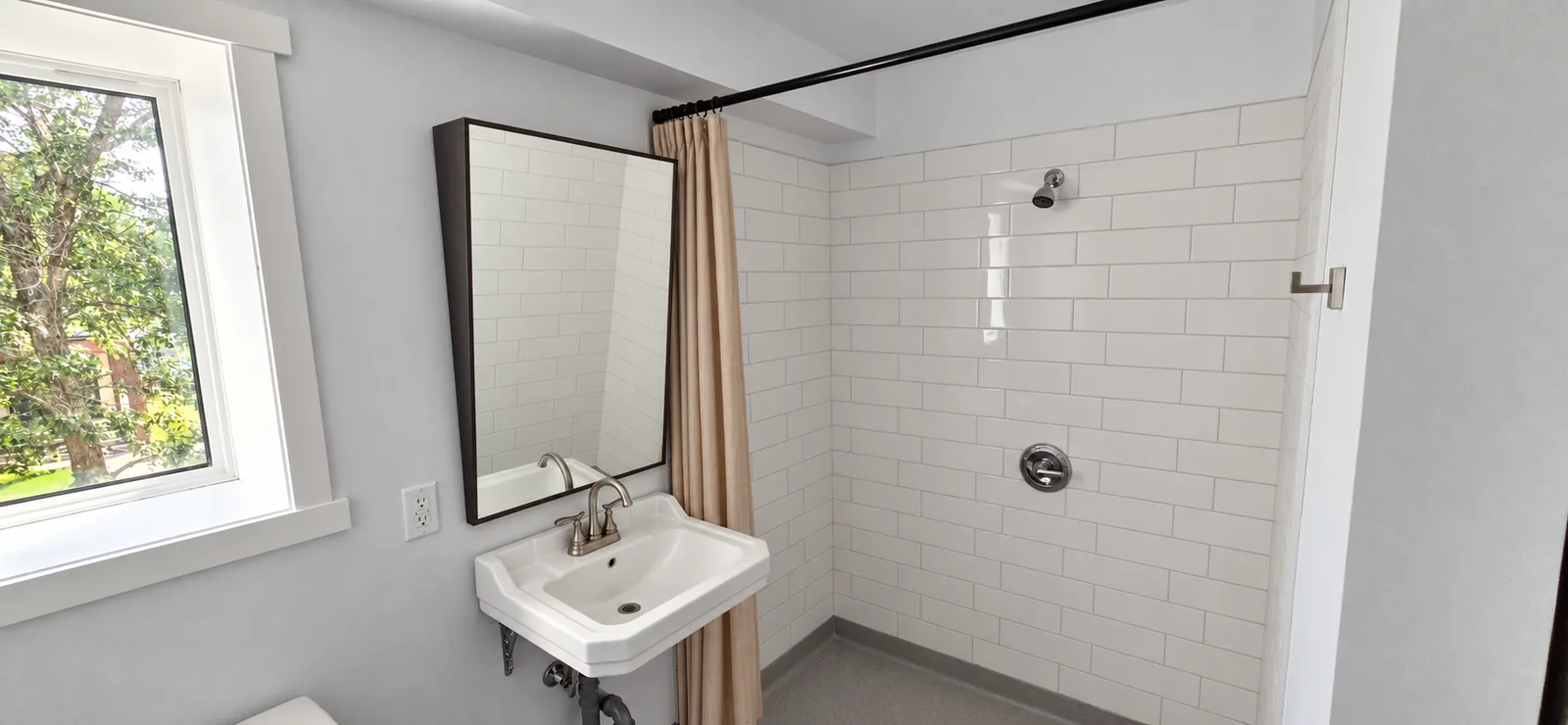 Tiled roll-in shower with wall-mounted sink