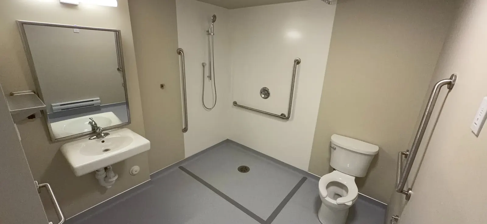 Barrier-free bathroom with roll-in shower and grab bars